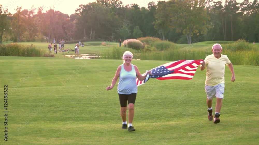 Couple with American flag. Front view of running people. Veterans of the sport. Victories and patriotism. Couple with American flag. Front view of running people. Veterans of the sport. Victories and patriotism.
