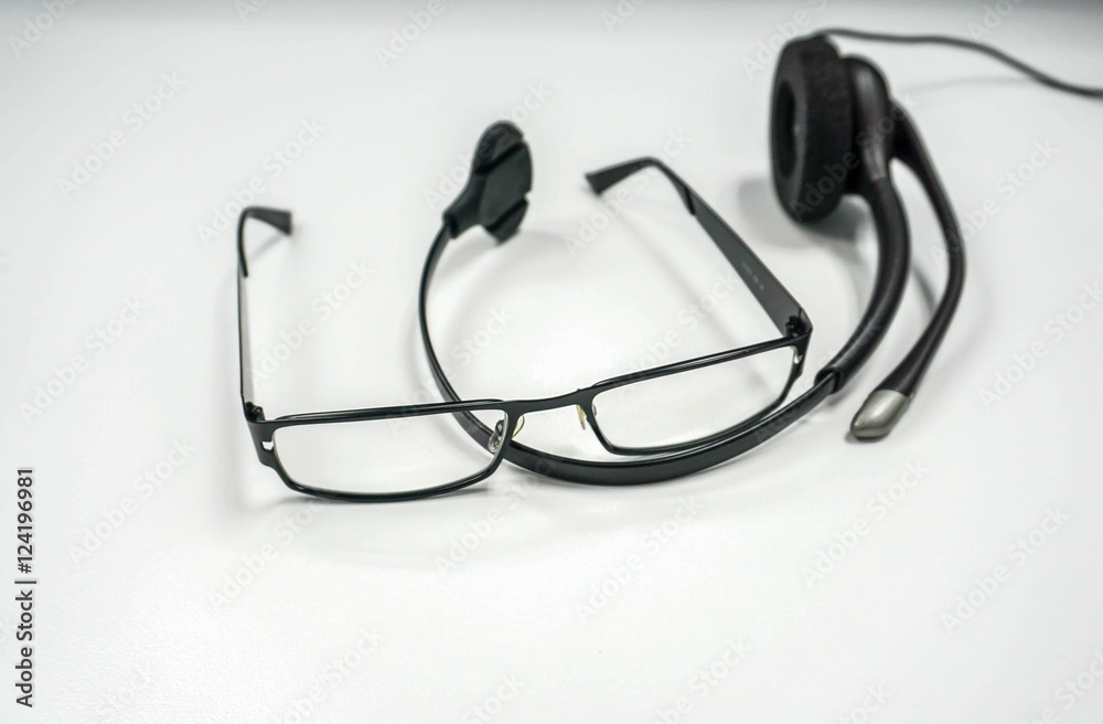 isolated men glasses with headset on the office desk isolated men glasses with headset on the office desk