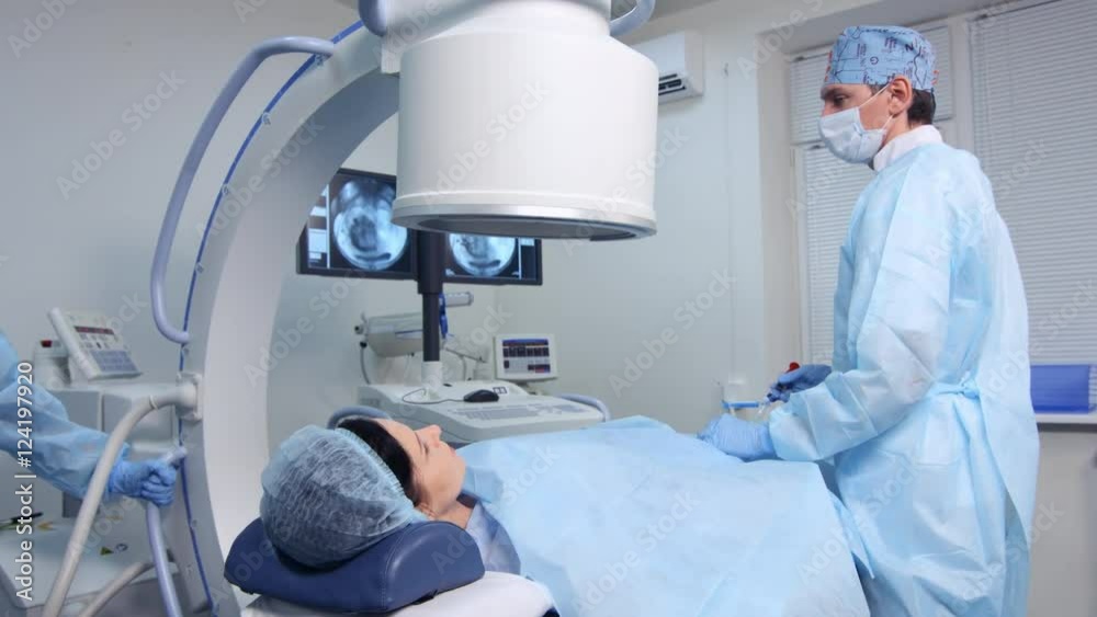 Interventional radiologist performs endovascular surgery operation with angiography machine,  ufe treatment
