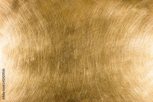 scratched industrial brass metal plate textured background pattern with light reflections photo