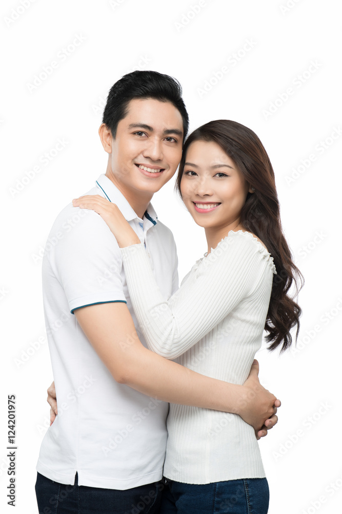 Happy couple hugging and kissing over white background Happy couple hugging and kissing over white background