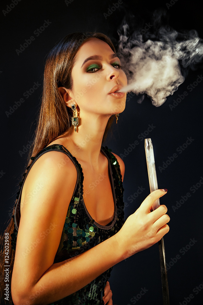 Obraz premium Young, beautiful girl in club dress and perfect make up smoke a