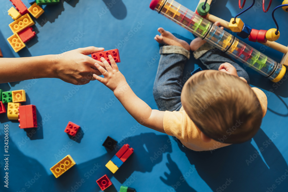 Fototapeta Happy baby playing with toy blocks.