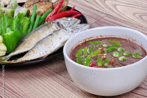 Close up of spicy shrimp paste dip as " Nam Prik Kapi" served with side dish as deep fired mackarel,boiled long-eggplant,lentils,winged bean ,red hot chili pepper and sliced cucumber. Selective focus.