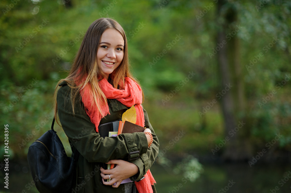 Cheerful student on the background of autumn park.