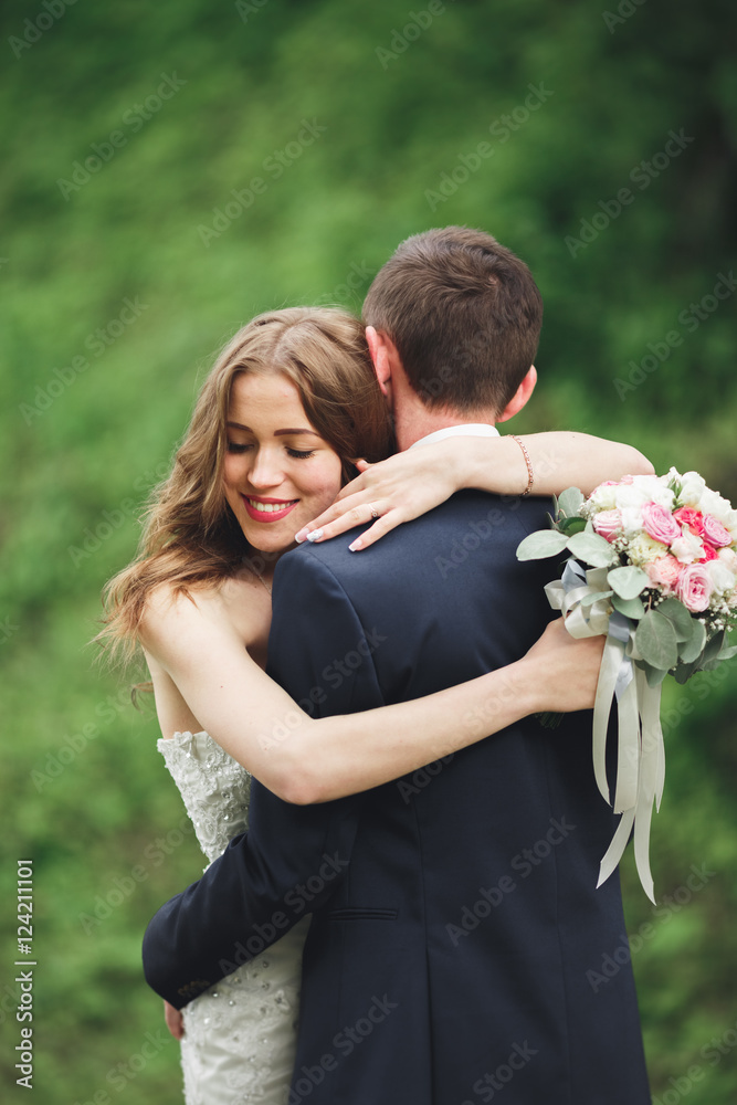 Happy wedding couple hugging and smiling each other on the background gorgeous plants in castle Happy wedding couple hugging and smiling each other on the background gorgeous plants in castle