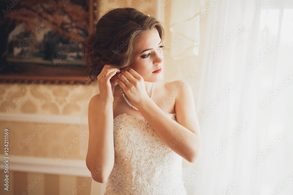 Luxury bride in white dress posing while preparing for the wedding ceremony Luxury bride in white dress posing while preparing for the wedding ceremony