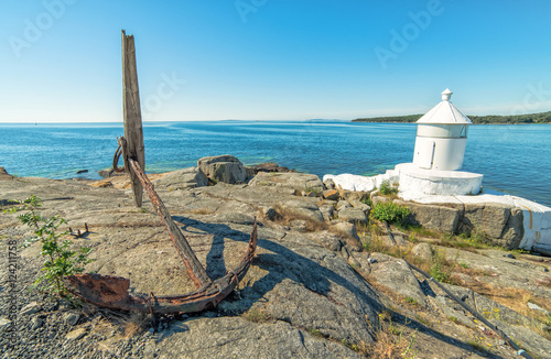 Swedish summer sea coast view with anchor and lighthouse