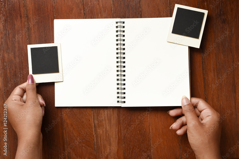 Obraz premium Blank notebook and photo frames on hand for background
