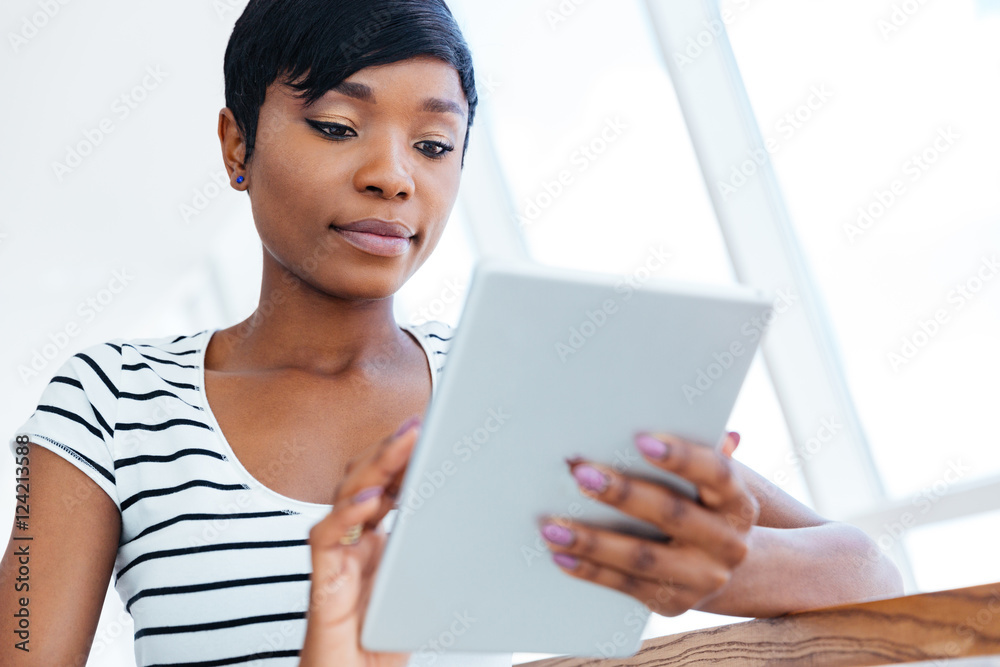 Attractive african businesswoman using tablet computer in office Attractive african businesswoman using tablet computer in office