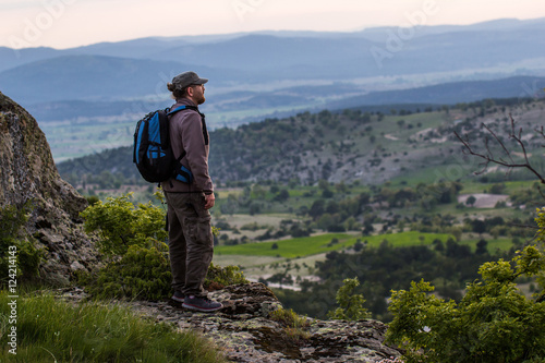 Man tourist hiker or trail runner looking in high mountains.