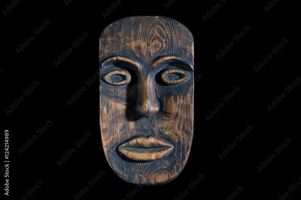 Ethnic tribal ritual handmade mask made from wood isolated on black background.