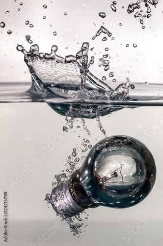 A tungsten lightbulb hits water with a splash
