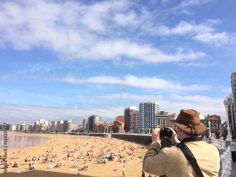 turista fotografiando la playa de Gijon 