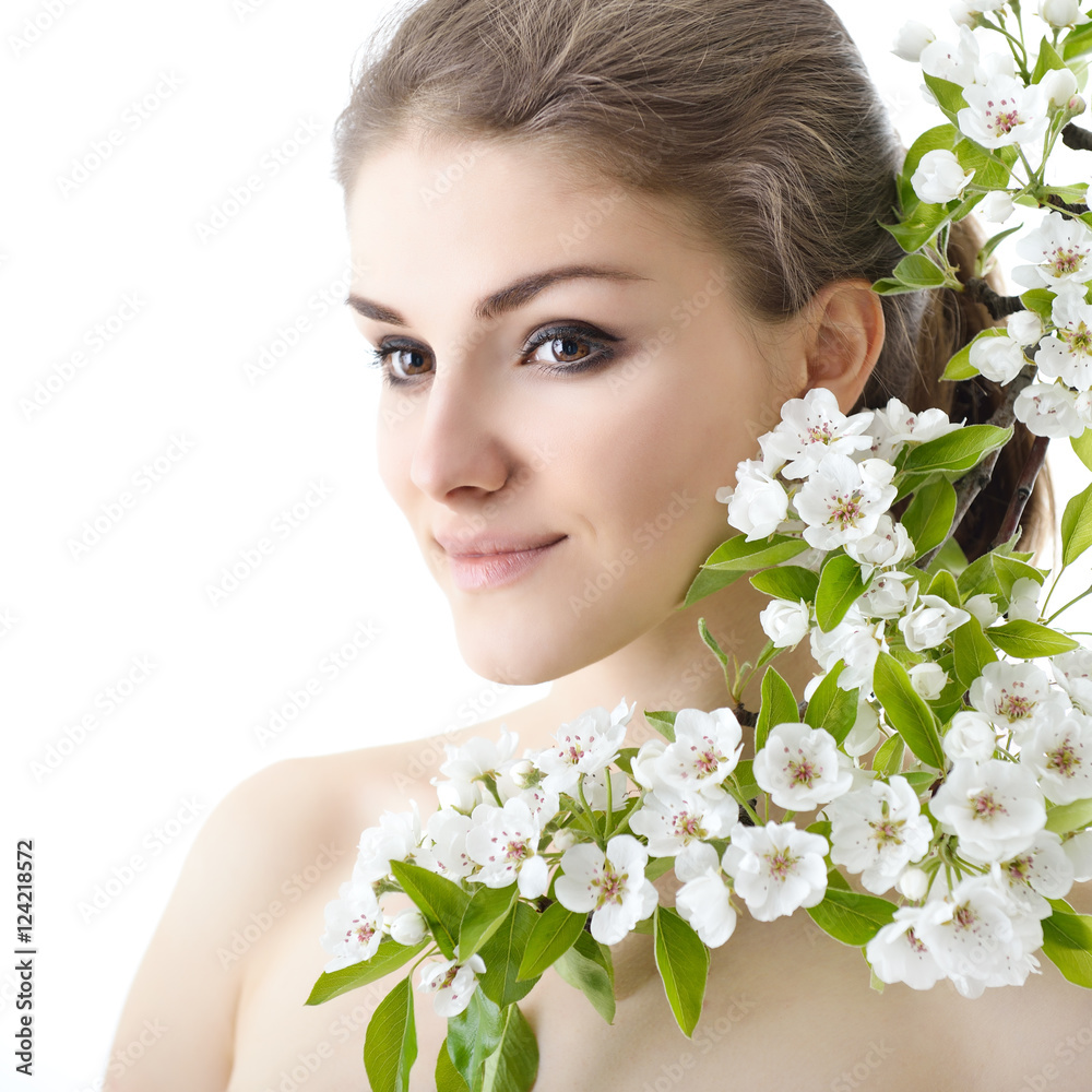 Beautiful happy young woman enjoying smell of a flowering spring