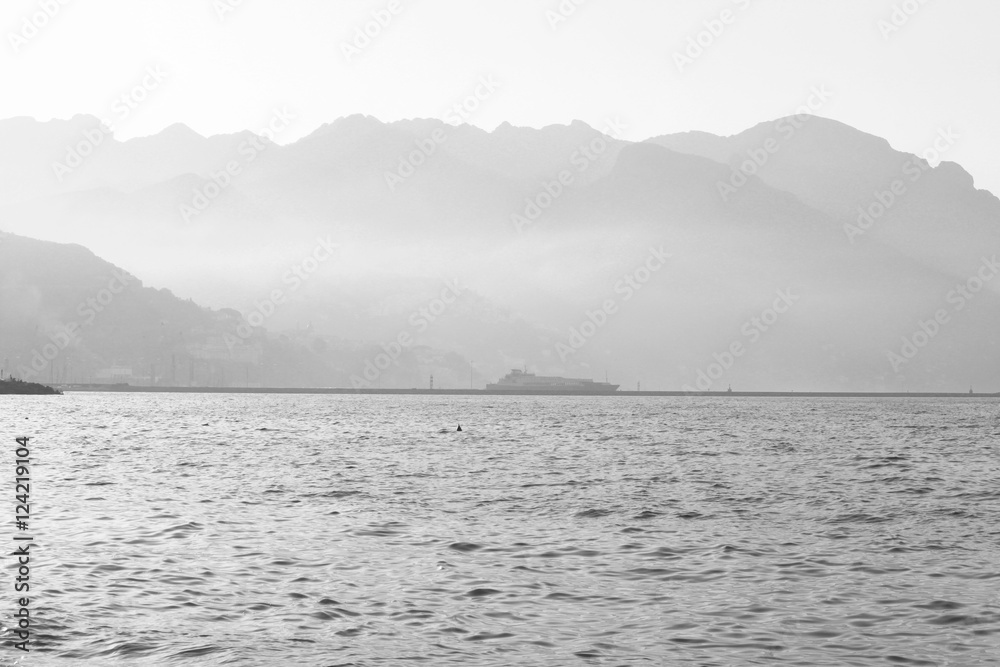 Black and white landscape with mountains, sky and fog