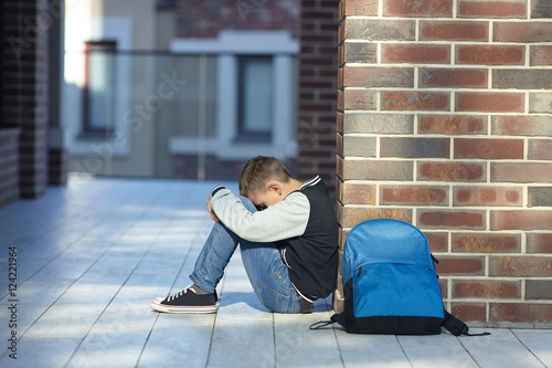schoolboy crying in the hallway of the school