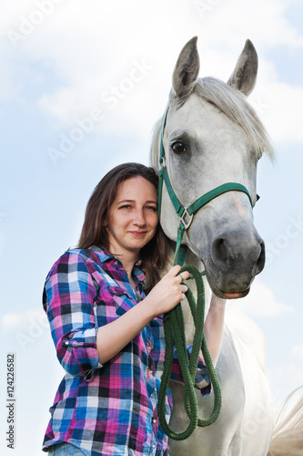 Beautiful young woman with her lovely white horse