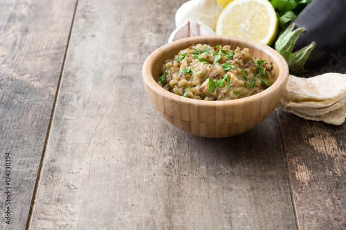 Baba ganoush and ingredients on wooden table

 photo