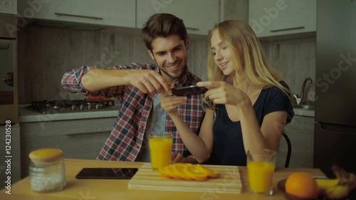 Couple making pictures of oranges.