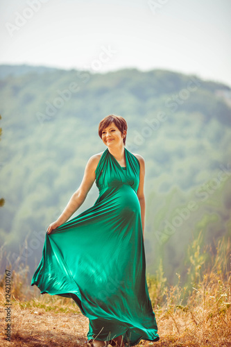 charming pregnant woman walking in nature