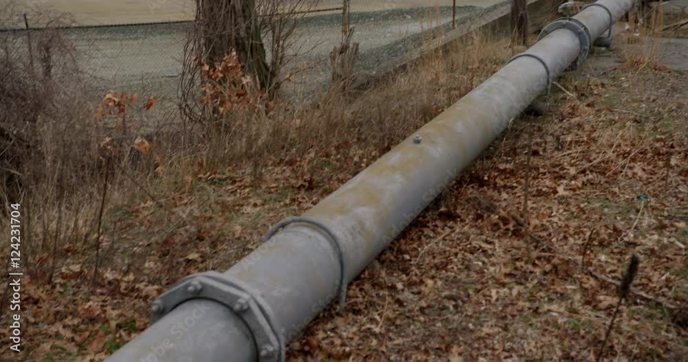Tilt up shot of old rusted oil pipeline near chemical storage tanks Tilt up shot of old rusted oil pipeline near chemical storage tanks