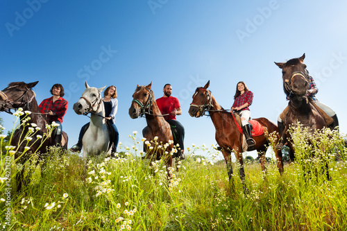 Portrait of happy equestrians riding their horses