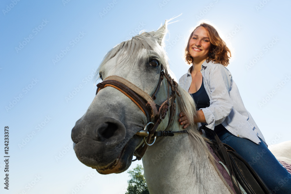 Obraz premium Portrait of happy young woman riding white horse