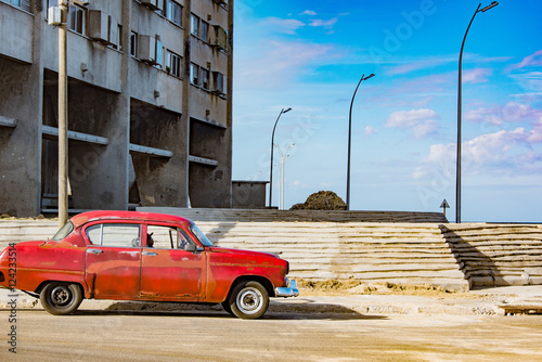 Fototapeta Naklejka Na Ścianę i Meble -  red vintage car in front of apartment house in havana, cuba