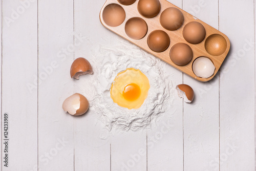 Egg in flour. Making dough background. Baking with raw eggs, sug