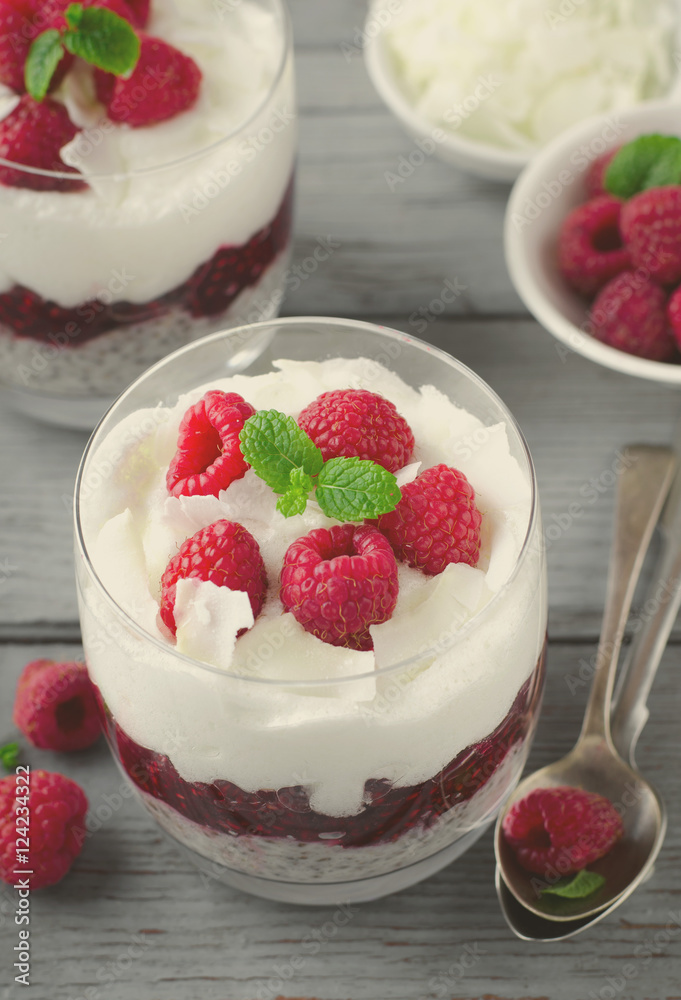 Healthy breakfast, desert, with chia seed pudding, cream, raspberry jam, coconut flakes and fresh berries