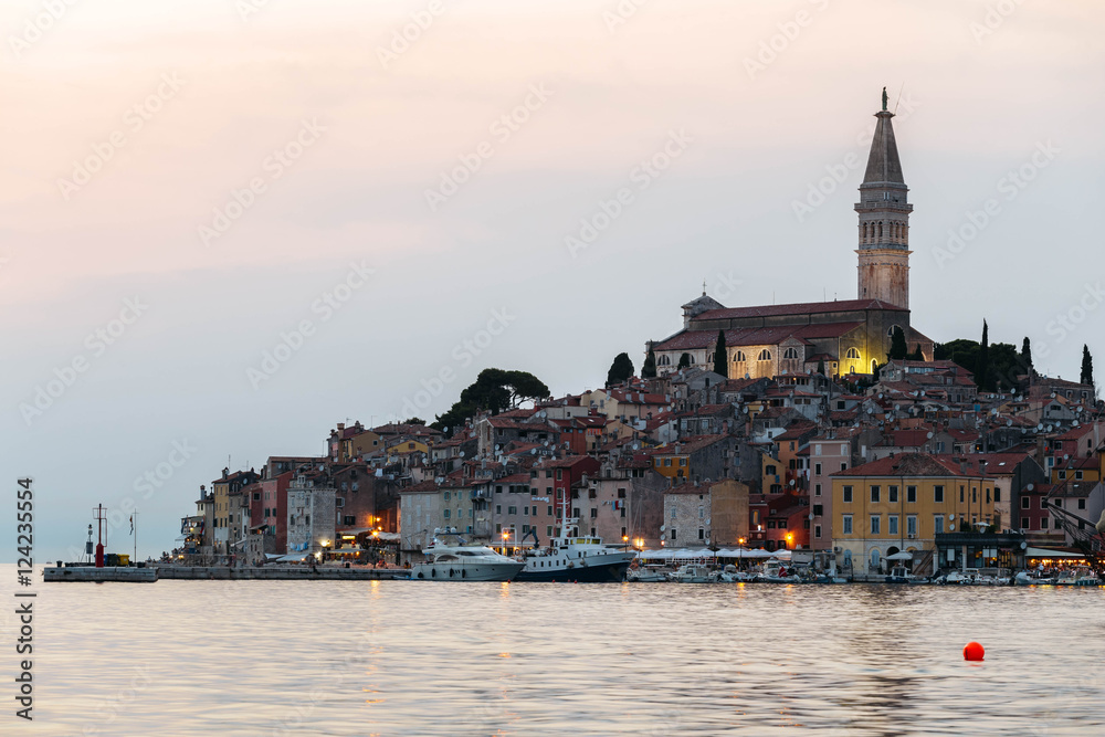 View of the historic part of Rovinj in Croatia during sunset. Above the town rises the Church of St. Euphemia. On the sea the ships.
