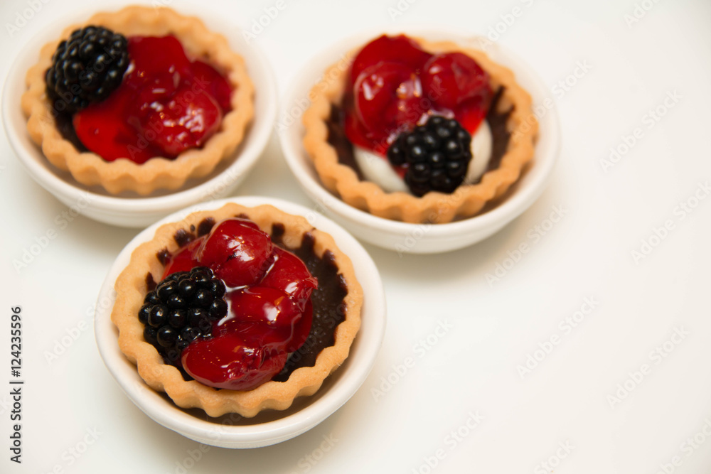 mini cherry pies/tarts on plates garnished with blackberry mini cherry pies/tarts on plates garnished with blackberry