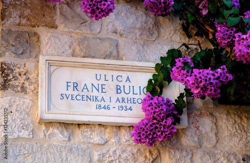 SPLIT, CROATIA, September 15, 2016 -  Beautiful croatian number plate of the road with bougainvillea flower on the street Frane Bulic near Diocletian palace, Split, Croatia photo