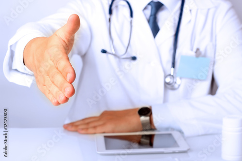Handshake Gesture from Doctor in a white labcoat and stethoscope