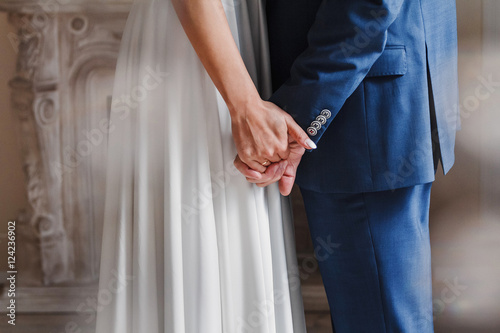 Closeup of a bride and groom holding hands