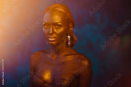 Splash of yellow light covers bronze woman