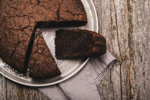 Healthy chocolate cake with beet on a gray plate with the effect of craquelure on the old wooden background. Selective focus. Toned  