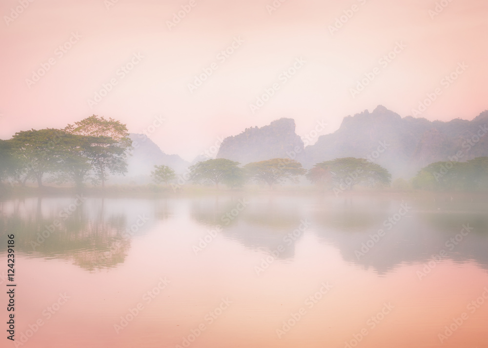 Amazing watercolor view of foggy morning landscape with trees reflection in lake water. Hpa An, Myanmar (Burma) travel landscapes and destinations