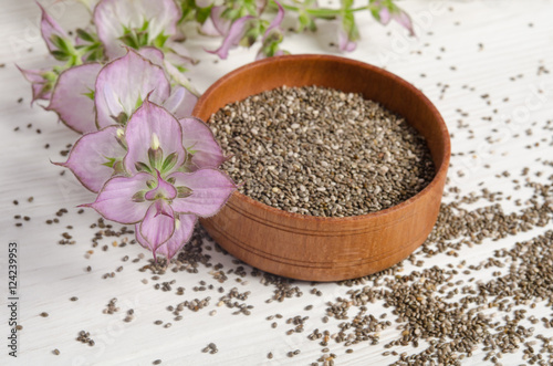 Chia seed healthy super food with flower over white wood backgro