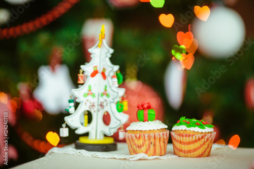 Toy Christmas tree and tasty little cupcakes stand on the table © pyrozenko13