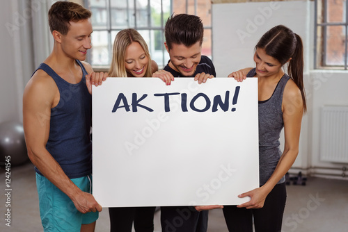 sportler im studio zeigen ein schild "aktion" © contrastwerkstatt