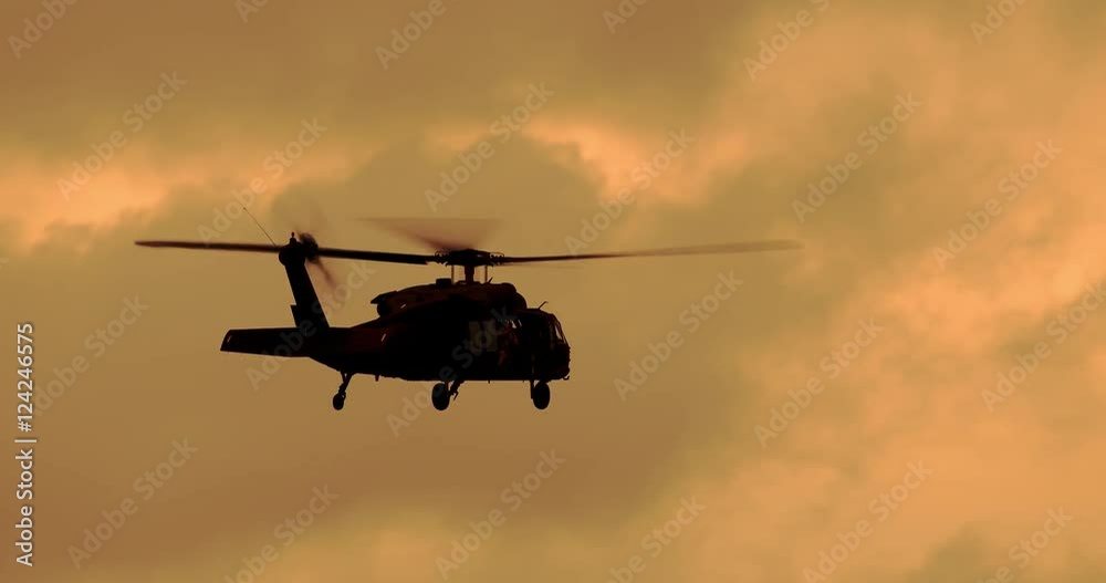 Tracking shot of black hawk helicopter flying in sky during sunset Tracking shot of black hawk helicopter flying in sky during sunset
