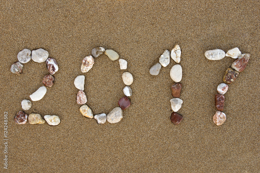 Pebble made New Year 2017 number on wet sandy beach Pebble made New Year 2017 number on wet sandy beach