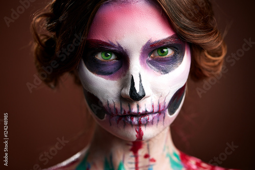 attractive young woman with sugar skull makeup 