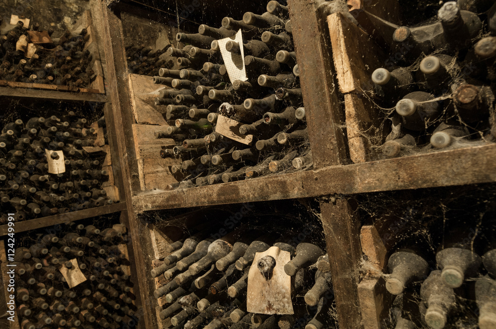 Φωτογραφία a lot of old wine bottles in the web in the wine cellar on the shelves