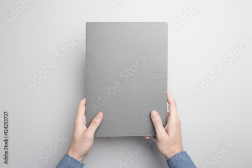 Hand is holding gray Notebook