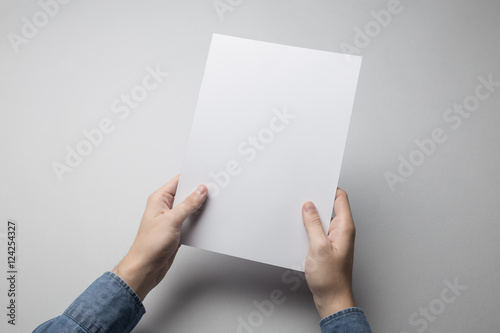 Hand holding Blank A4 Flyer / Invitation Mock-up.