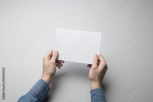 Hand holding Blank A5 Flyer / Invitation Mock-up.