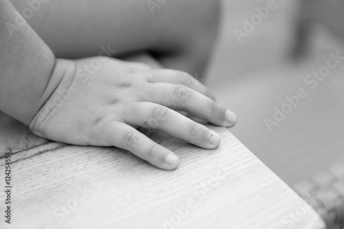 closeup of a child's hand sitting on a desk,